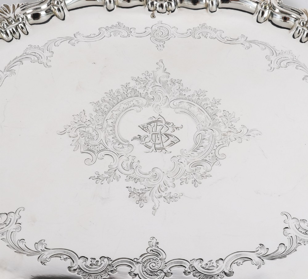 An oval Victorian silver plated serving tray featuring engraved scrollwork, cast shell borders, and dual side handles. View VII