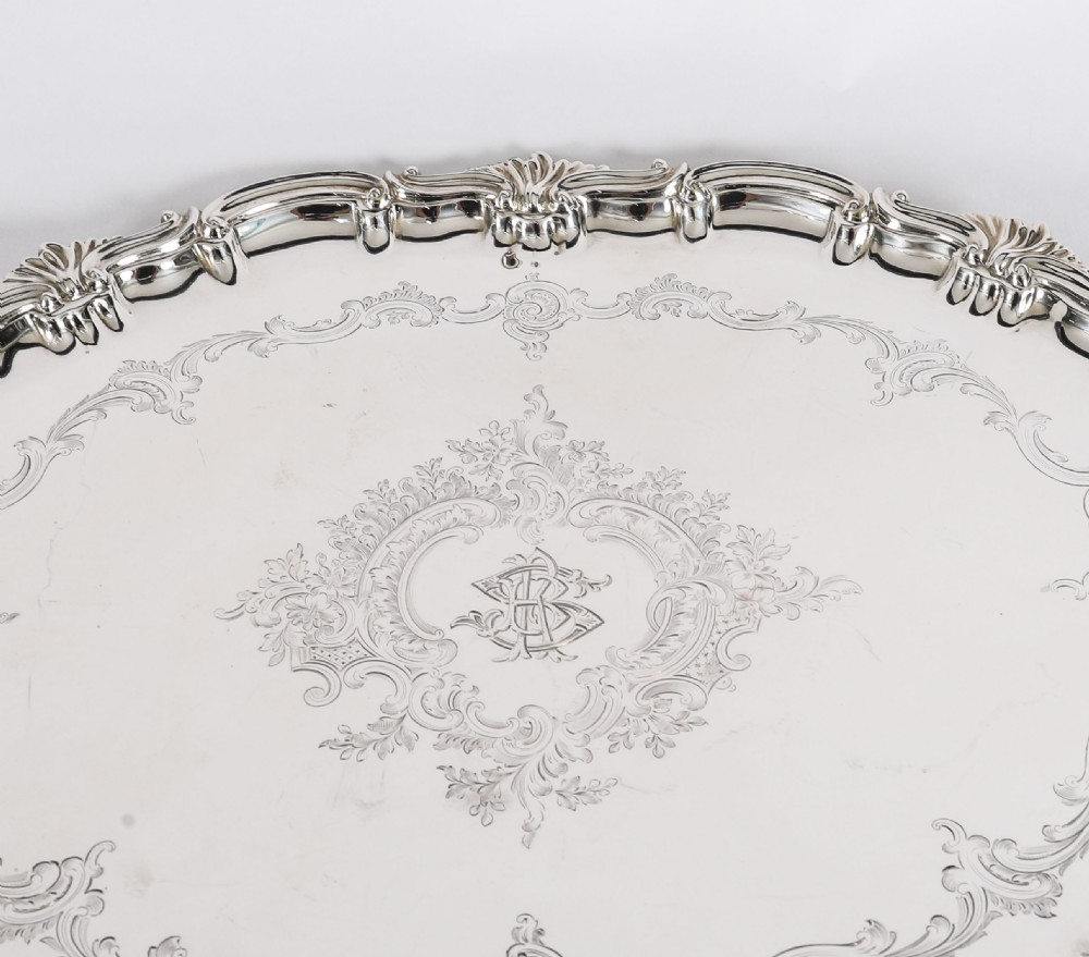 An oval Victorian silver plated serving tray featuring engraved scrollwork, cast shell borders, and dual side handles. View VIII
