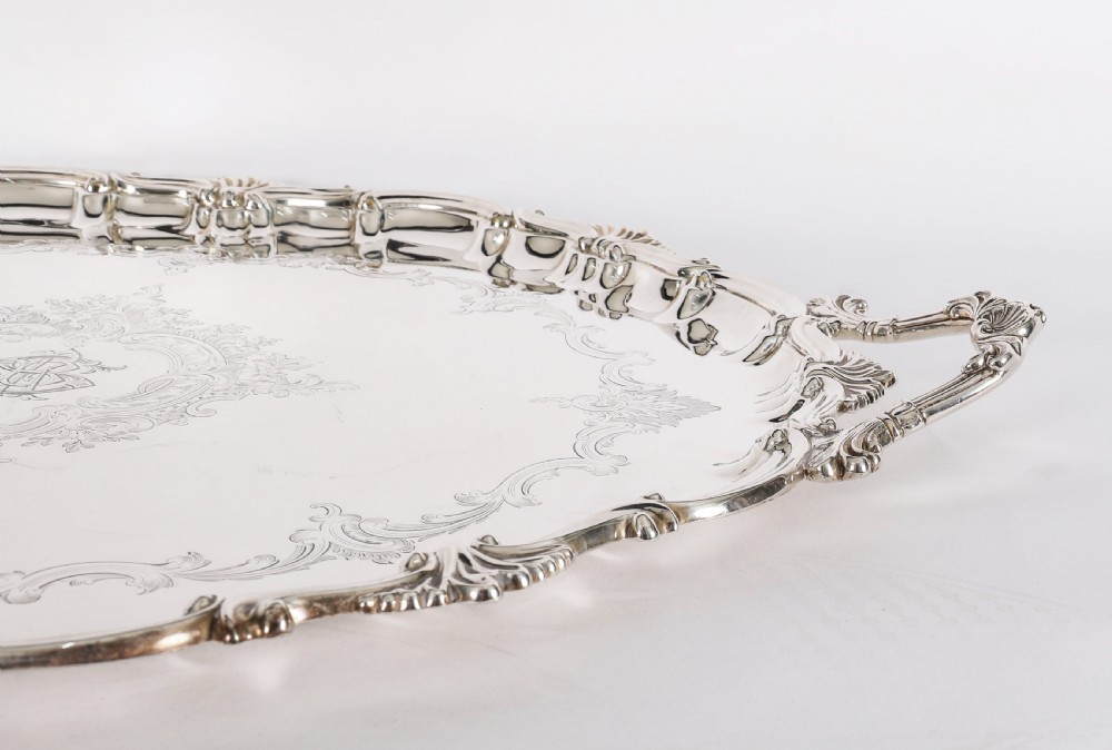 An oval Victorian silver plated serving tray featuring engraved scrollwork, cast shell borders, and dual side handles. View XI