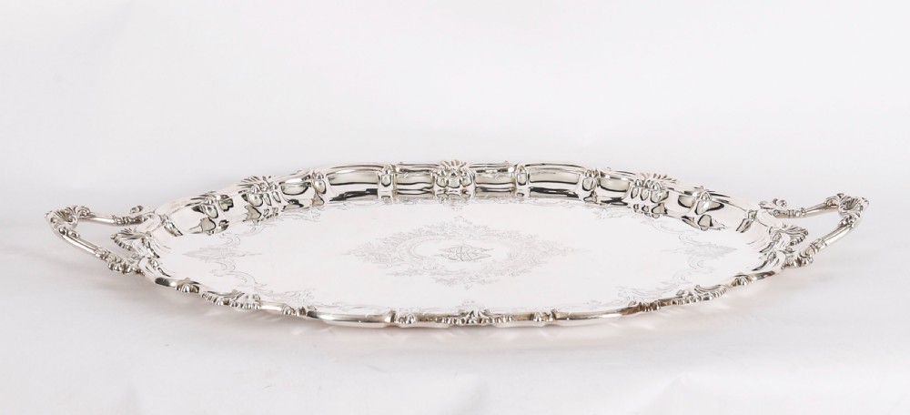 An oval Victorian silver plated serving tray featuring engraved scrollwork, cast shell borders, and dual side handles. View XIV