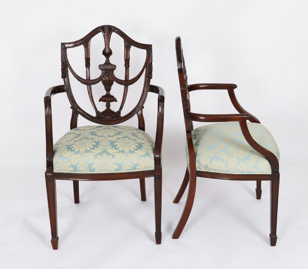 A pair of 20th-century mahogany Federal Revival armchairs featuring carved shield backs with central urn splats and blue patterned damask seats. View II