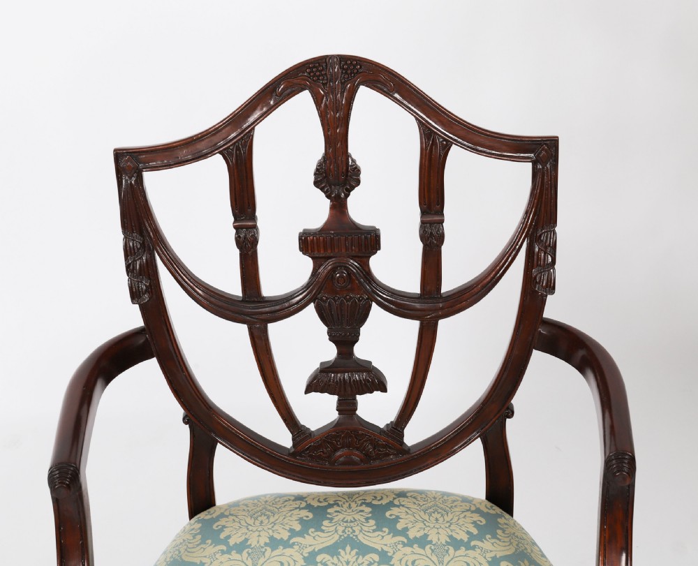 A pair of 20th-century mahogany Federal Revival armchairs featuring carved shield backs with central urn splats and blue patterned damask seats. View V