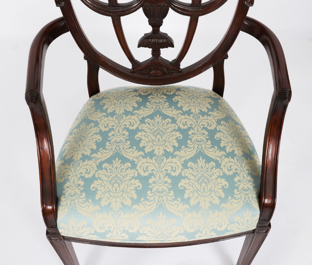A pair of 20th-century mahogany Federal Revival armchairs featuring carved shield backs with central urn splats and blue patterned damask seats. View VI