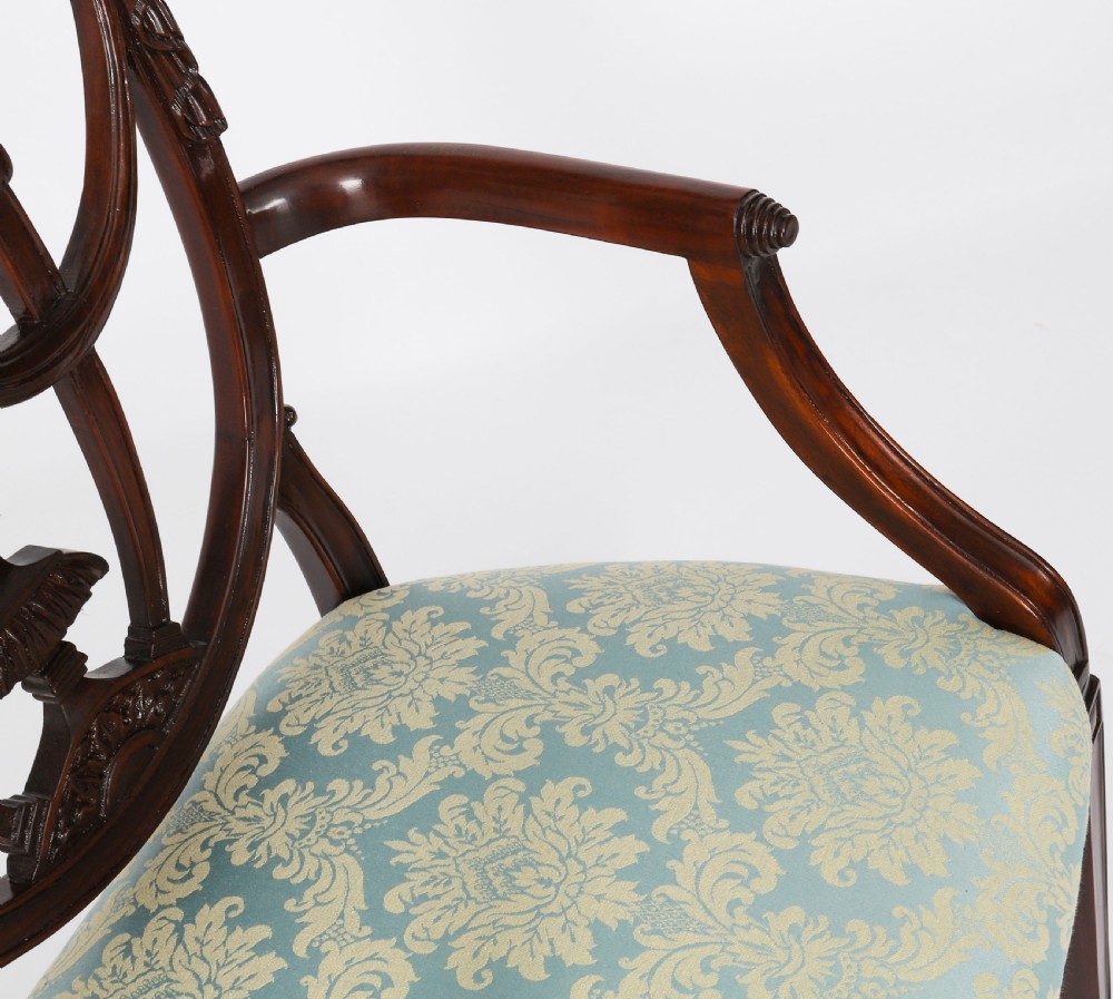 A pair of 20th-century mahogany Federal Revival armchairs featuring carved shield backs with central urn splats and blue patterned damask seats. View VII