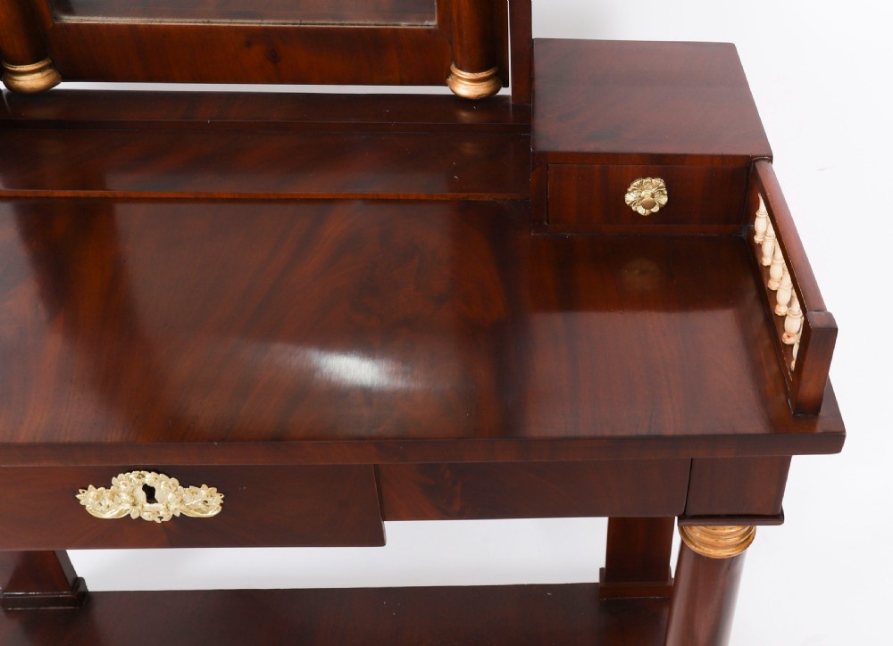 A 19th-century French Empire mahogany dressing table with a central adjustable mirror, gilded column supports, small side drawers, and a lower curved stretcher. View V