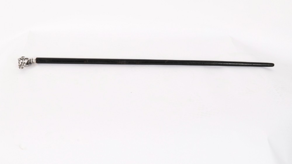 A dark wooden walking stick featuring a silver handle cast in the form of a horse head.