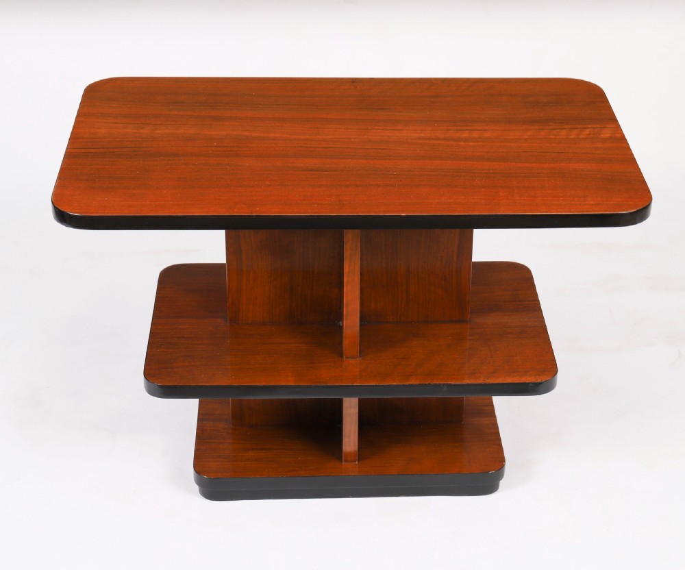 An antique Art Deco tiered walnut coffee table featuring rounded rectangular surfaces, central vertical dividers, and dark ebonised trim on a plain background. View II