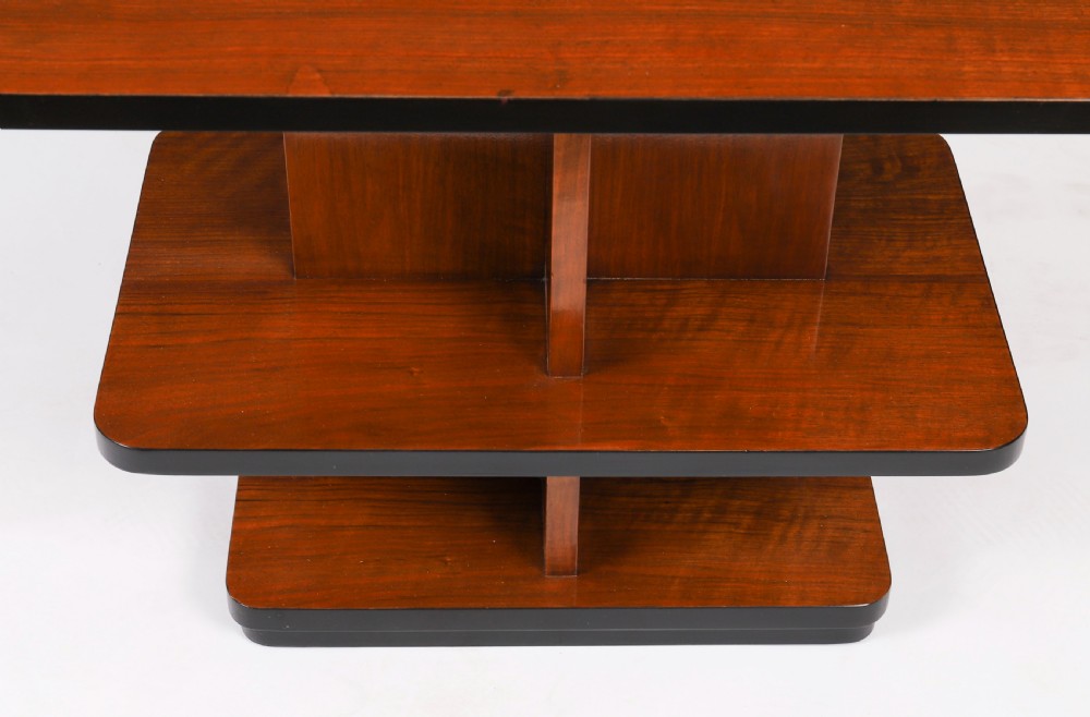 An antique Art Deco tiered walnut coffee table featuring rounded rectangular surfaces, central vertical dividers, and dark ebonised trim on a plain background. View IV