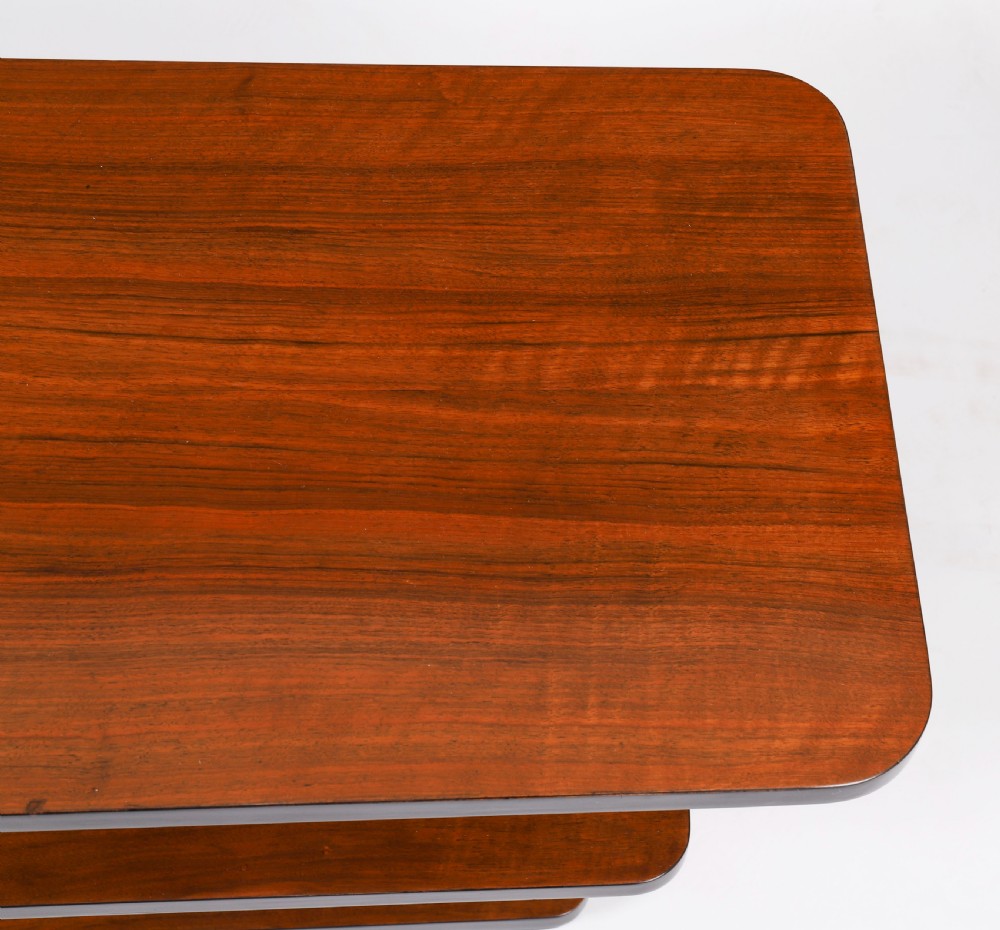 An antique Art Deco tiered walnut coffee table featuring rounded rectangular surfaces, central vertical dividers, and dark ebonised trim on a plain background. View V