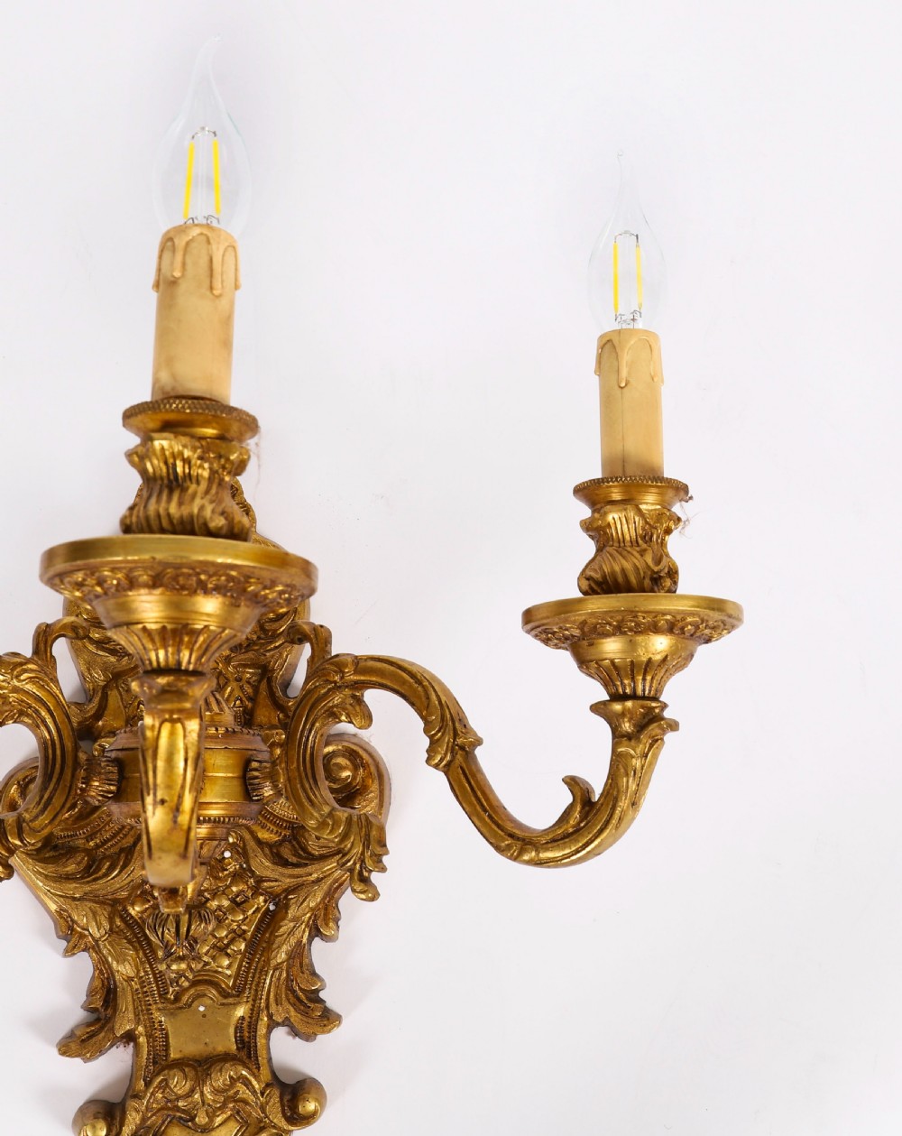 A pair of French gilt bronze three-arm wall sconces featuring scrolled foliate ornamentation and decorative backplates. View VI