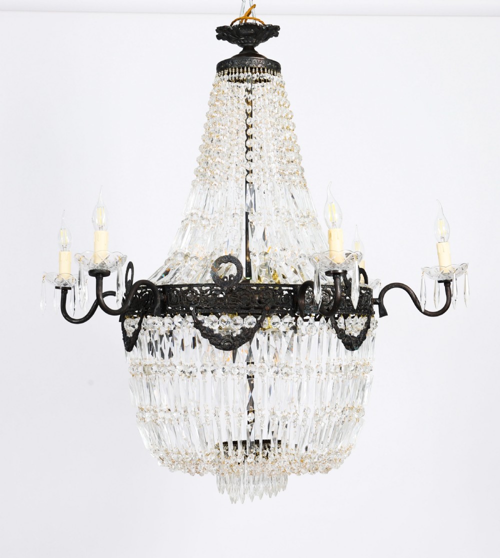 A large 1920s Louis Revival tent chandelier featuring an upper cone and lower basket of cut crystal beads set on a patinated bronze band with fourteen radiating candle arms. View V