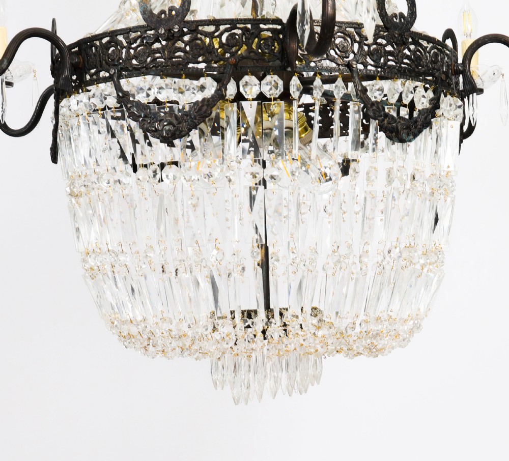 A large 1920s Louis Revival tent chandelier featuring an upper cone and lower basket of cut crystal beads set on a patinated bronze band with fourteen radiating candle arms. View VII