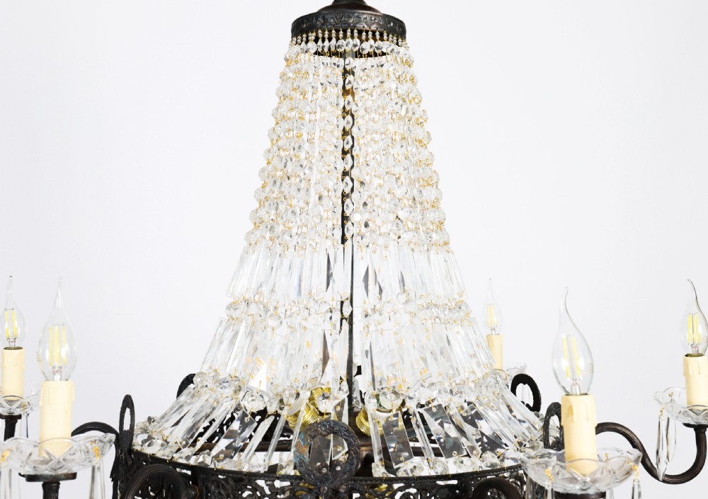 A large 1920s Louis Revival tent chandelier featuring an upper cone and lower basket of cut crystal beads set on a patinated bronze band with fourteen radiating candle arms. View IX