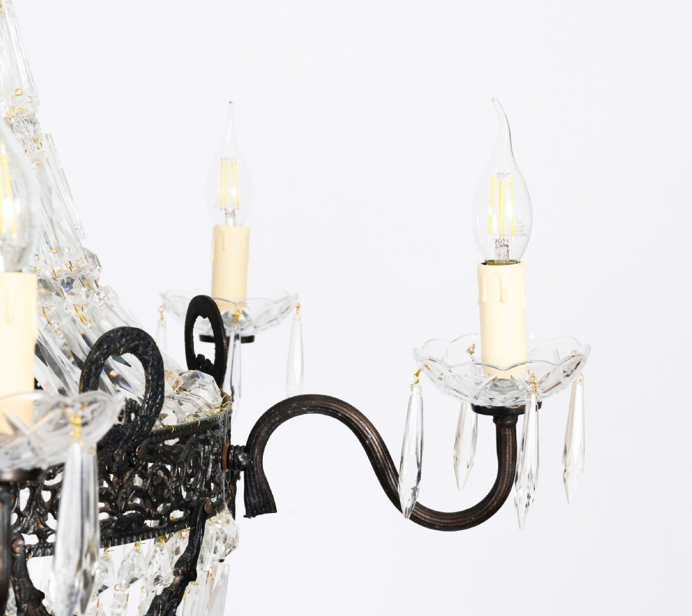 A large 1920s Louis Revival tent chandelier featuring an upper cone and lower basket of cut crystal beads set on a patinated bronze band with fourteen radiating candle arms. View XII