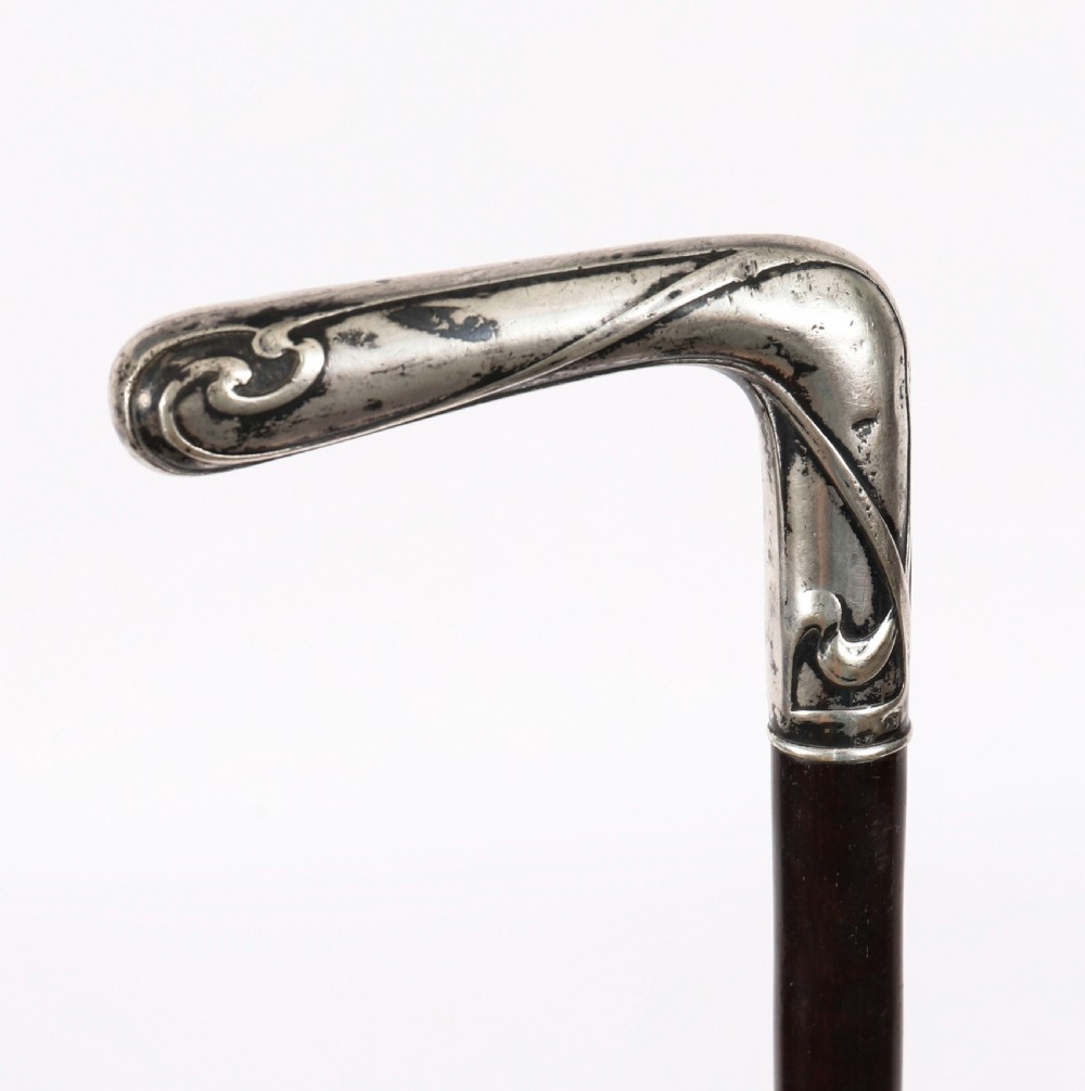 A 19th-century French walking cane featuring an L-shaped silver handle mounted on a dark wooden shaft. View IV