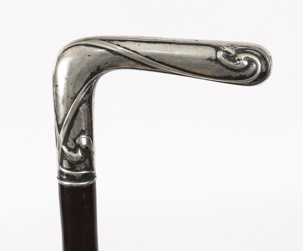 A 19th-century French walking cane featuring an L-shaped silver handle mounted on a dark wooden shaft. View V
