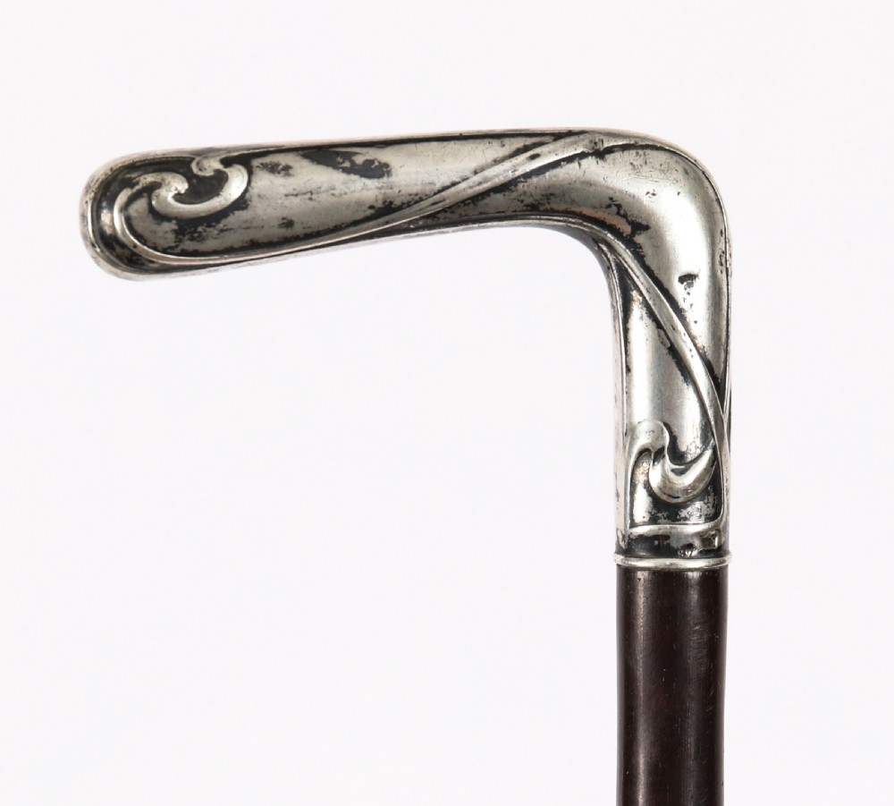 A 19th-century French walking cane featuring an L-shaped silver handle mounted on a dark wooden shaft. View VI