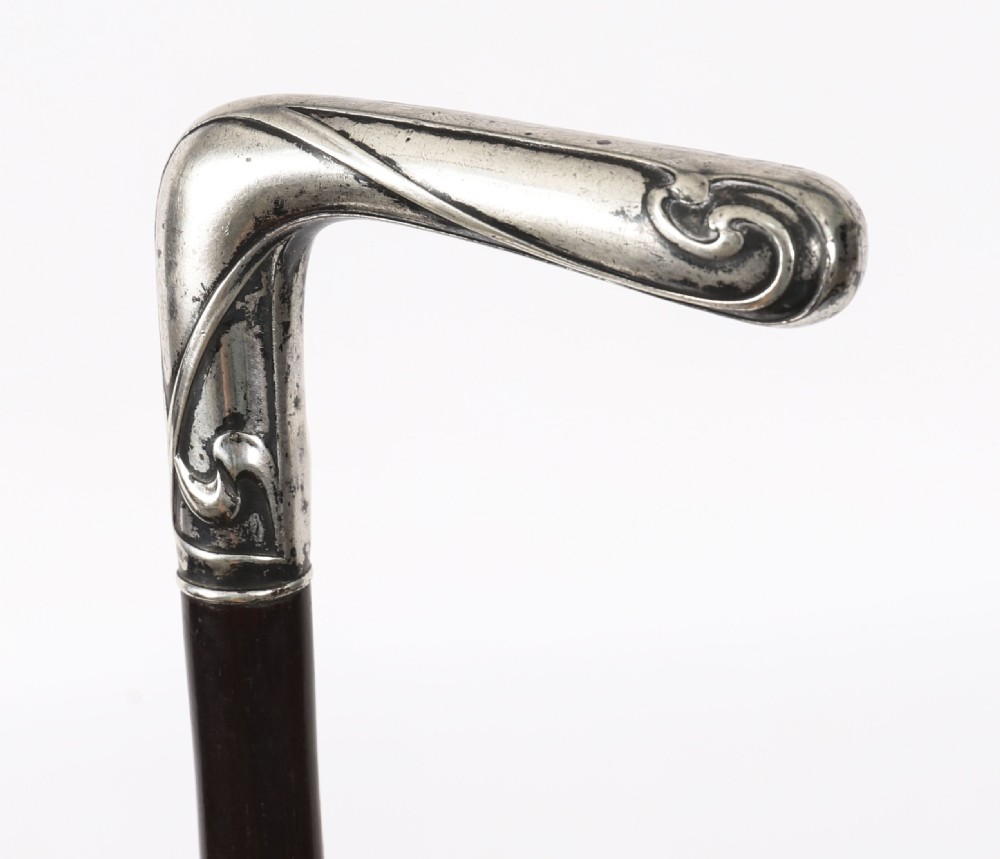 A 19th-century French walking cane featuring an L-shaped silver handle mounted on a dark wooden shaft. View IX