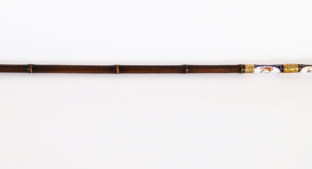 A 19th-century French walking stick featuring a dark wood shaft and a gold-plated pommel adorned with painted porcelain inserts. View VI