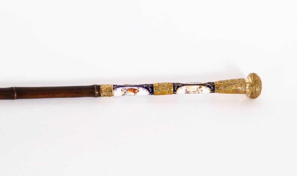 A 19th-century French walking stick featuring a dark wood shaft and a gold-plated pommel adorned with painted porcelain inserts. View VII