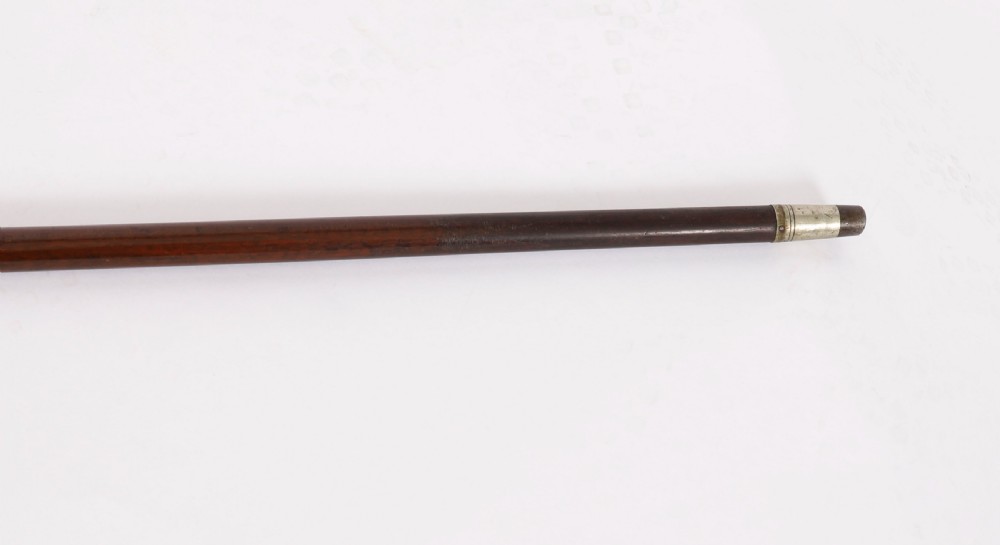 An antique walking stick featuring a detailed silver handle depicting a fox and hare, set atop a dark wood shaft with a metal ferrule. View VI