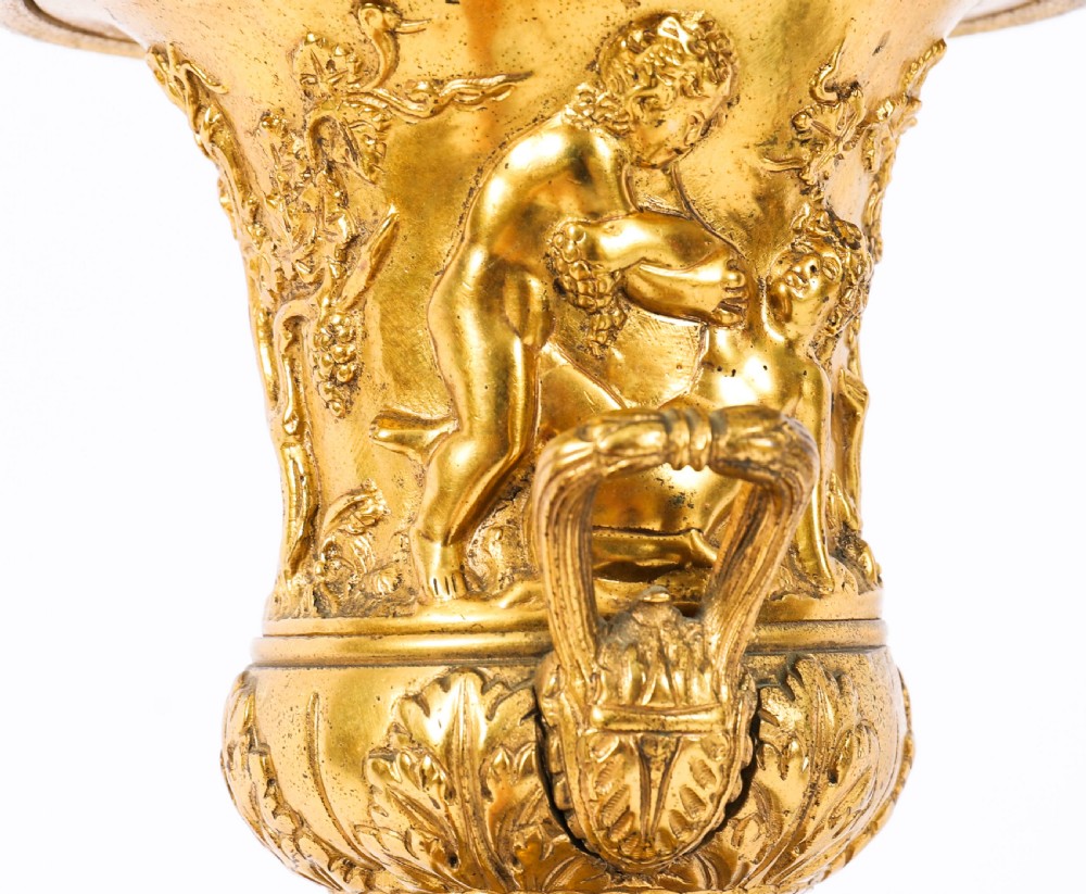 A pair of 19th-century French Grand Tour gilt bronze campana urns featuring classical figure reliefs, mounted on square green marble pedestal bases with gilt laurel wreaths. View X
