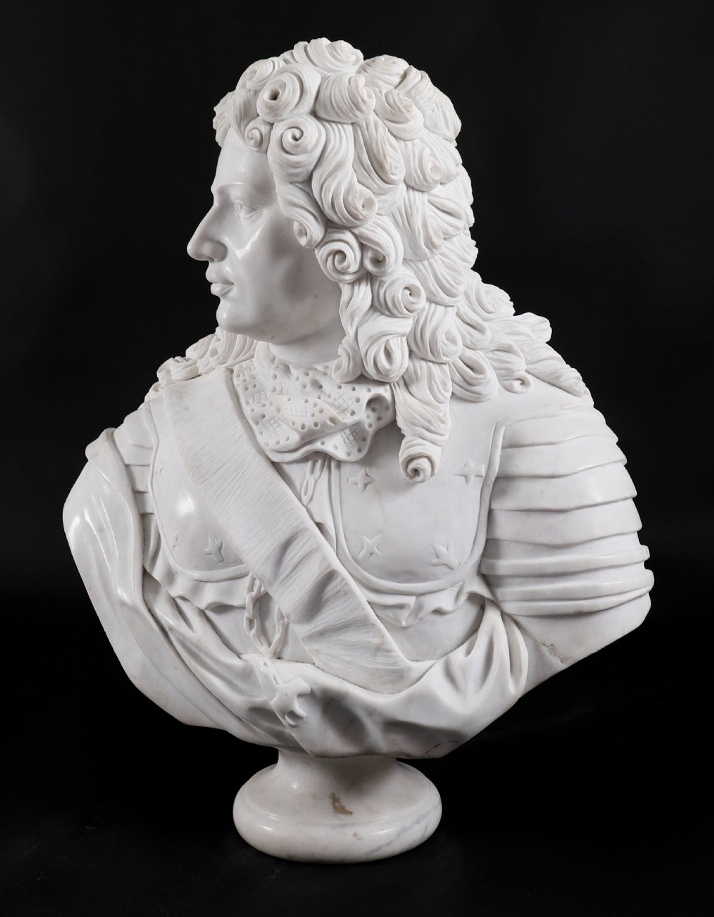 Carved white marble bust depicting a nobleman with long curled hair, lace cravat, and plate armour on a turned circular pedestal. View VII