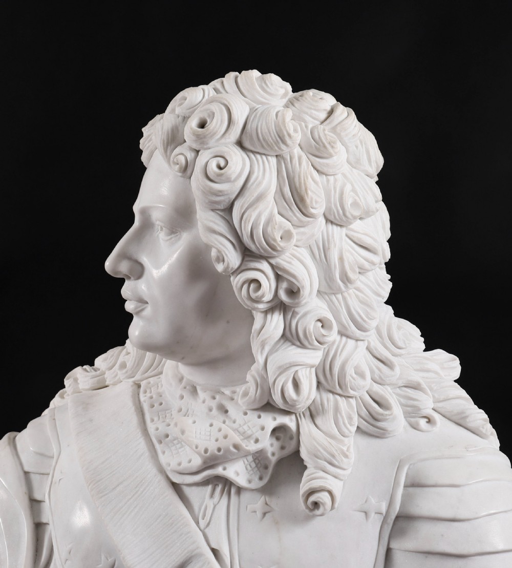 Carved white marble bust depicting a nobleman with long curled hair, lace cravat, and plate armour on a turned circular pedestal. View X