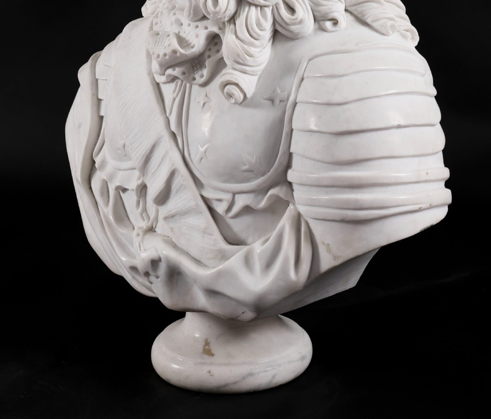 Carved white marble bust depicting a nobleman with long curled hair, lace cravat, and plate armour on a turned circular pedestal. View XI