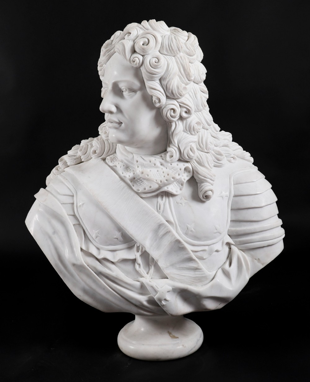 Carved white marble bust depicting a nobleman with long curled hair, lace cravat, and plate armour on a turned circular pedestal. View XV