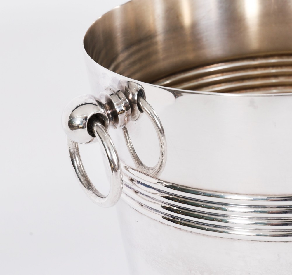 An Art Deco silver-plated champagne cooler featuring reeded horizontal bands and twin drop-ring handles on spherical mounts. View VIII