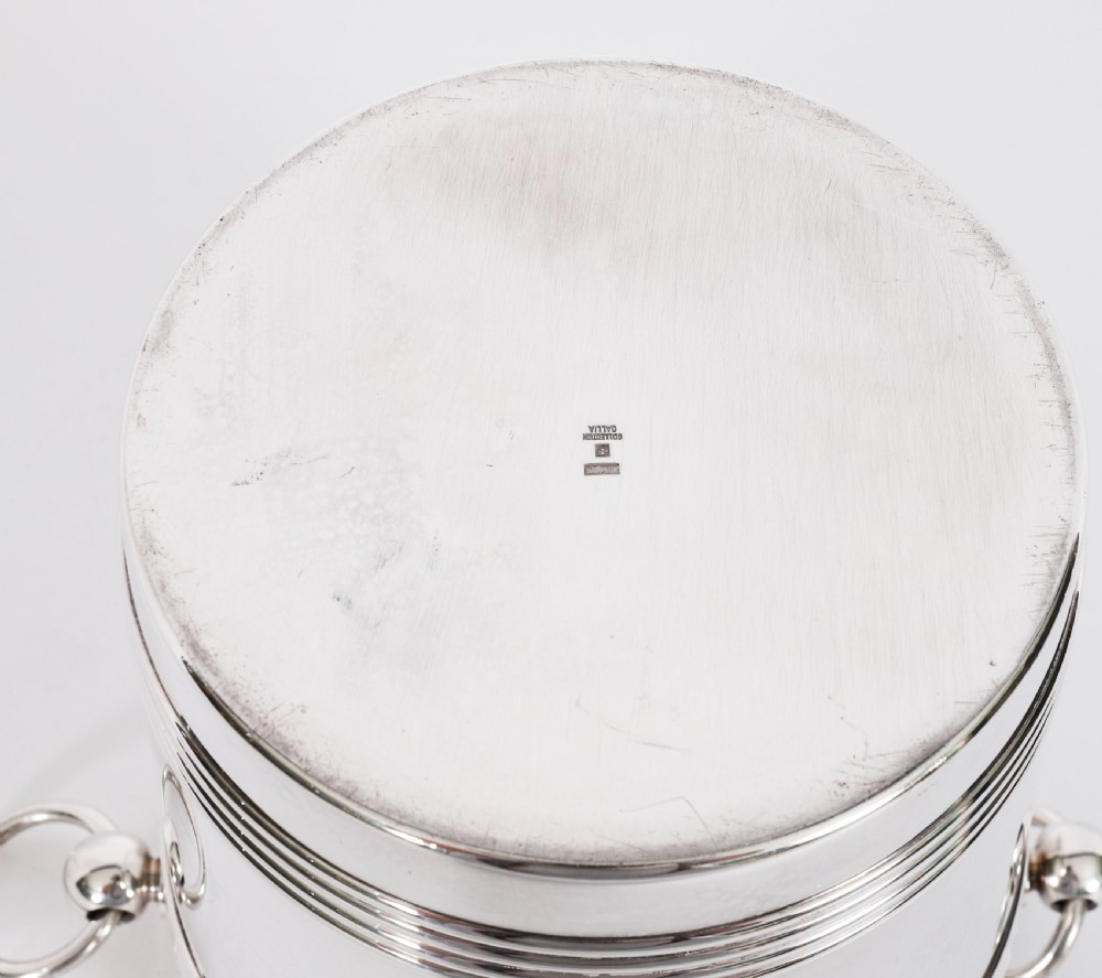An Art Deco silver-plated champagne cooler featuring reeded horizontal bands and twin drop-ring handles on spherical mounts. View XII