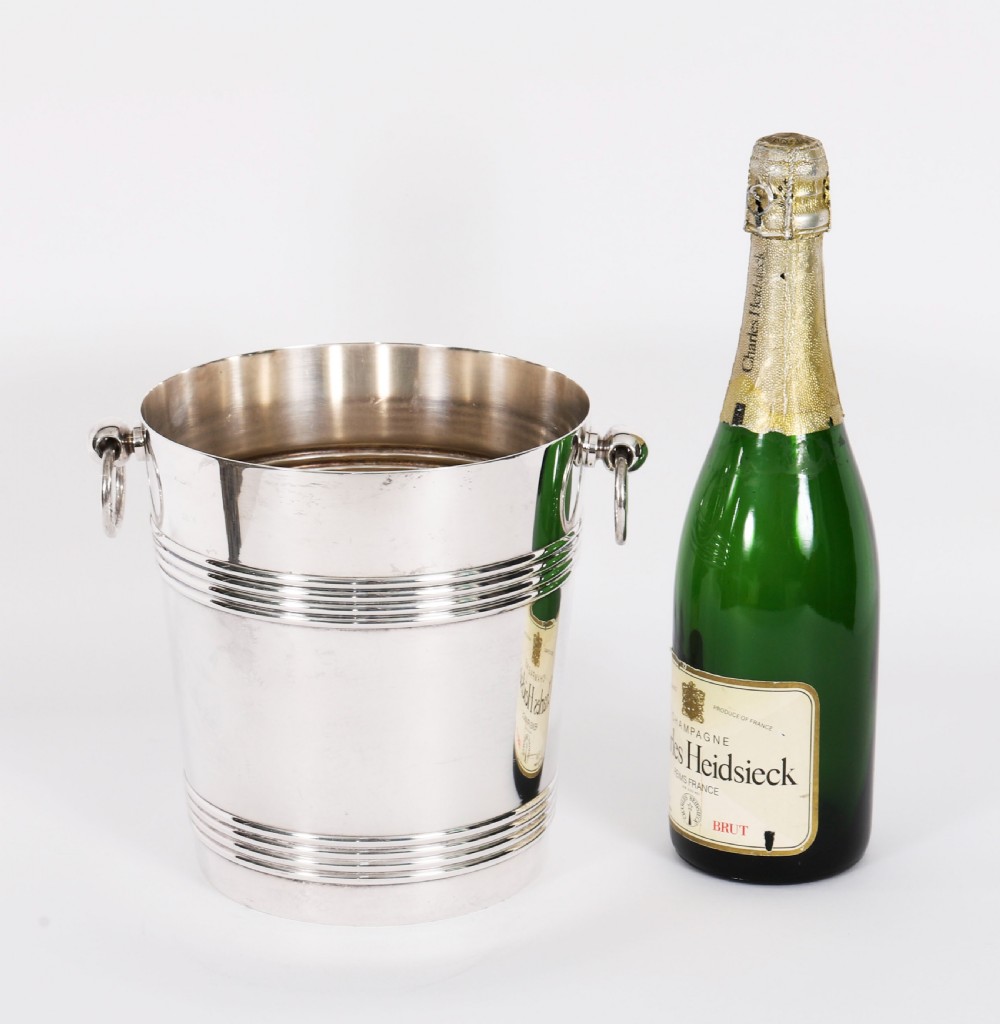An Art Deco silver-plated champagne cooler featuring reeded horizontal bands and twin drop-ring handles on spherical mounts. View XV