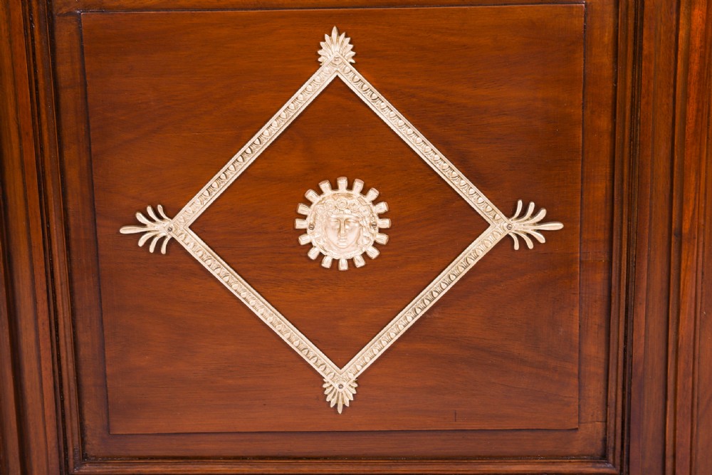A nineteenth-century French Empire Revival mahogany bookcase featuring twin glazed doors, gilt bronze mounts, a marble top, and metal paw feet. View VIII