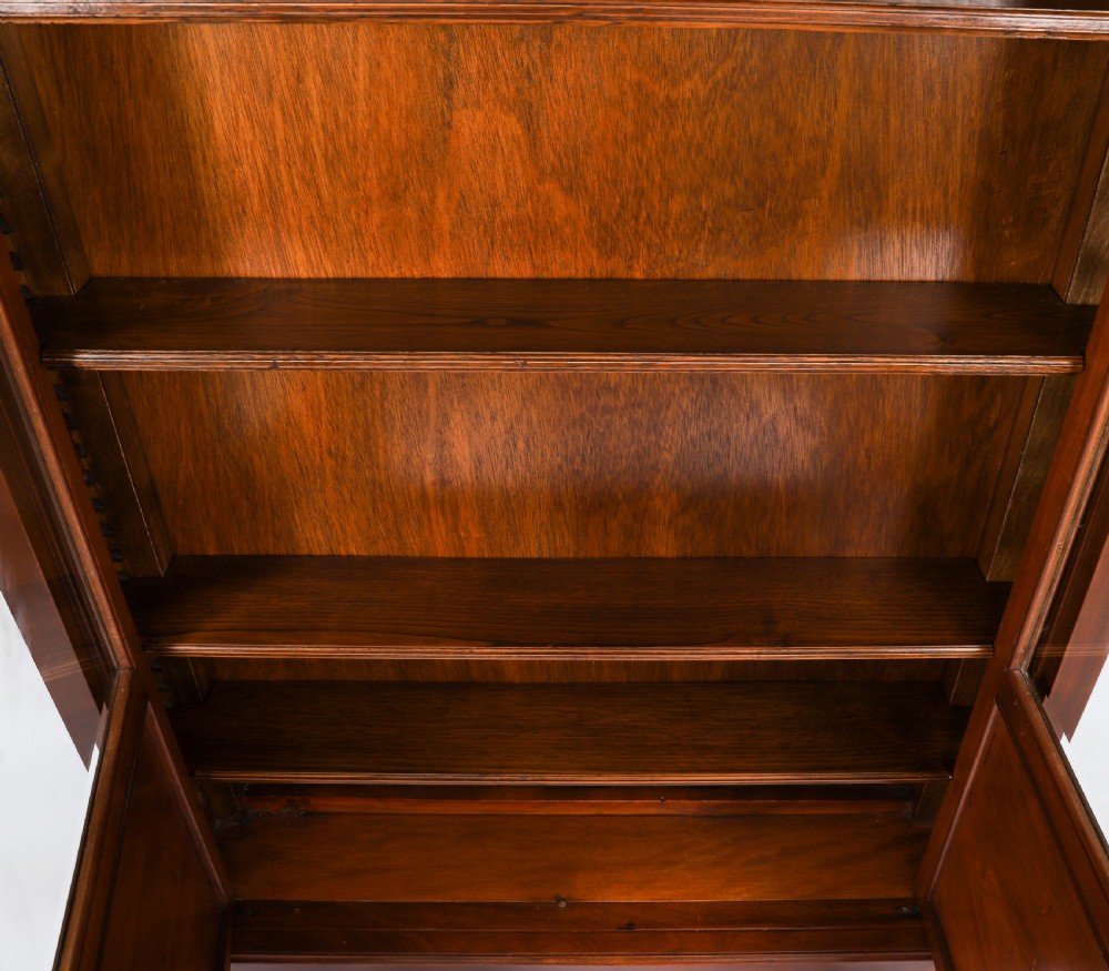 A nineteenth-century French Empire Revival mahogany bookcase featuring twin glazed doors, gilt bronze mounts, a marble top, and metal paw feet. View XIV