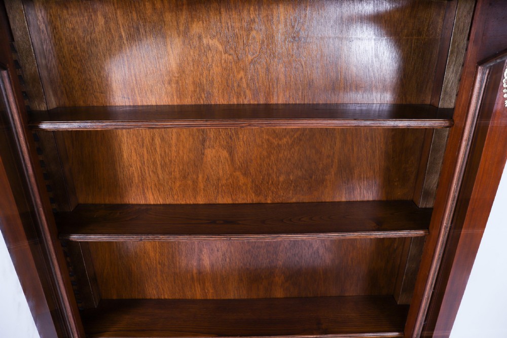A nineteenth-century French Empire Revival mahogany bookcase featuring twin glazed doors, gilt bronze mounts, a marble top, and metal paw feet. View XV