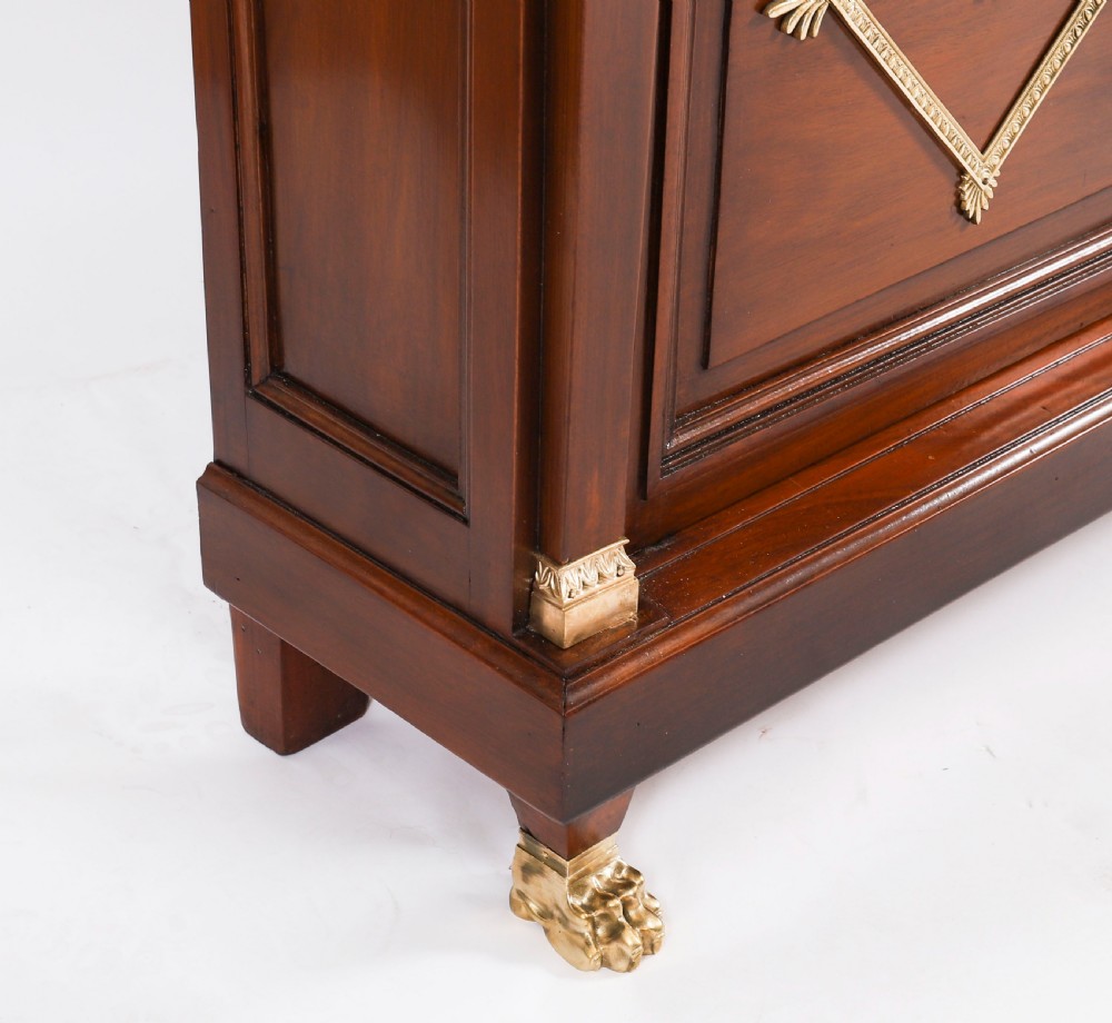 A nineteenth-century French Empire Revival mahogany bookcase featuring twin glazed doors, gilt bronze mounts, a marble top, and metal paw feet. View XVI