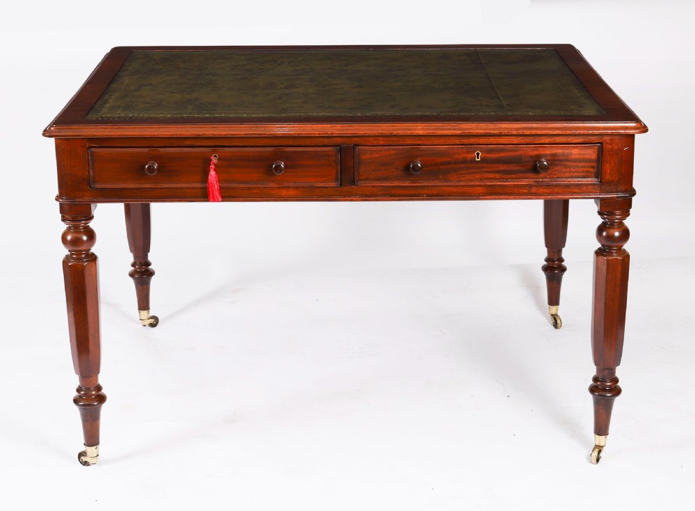 A nineteenth-century Victorian mahogany partners writing desk featuring a green leather inset top, frieze drawers with turned wood knob handles, and tapered legs on brass castors. View II