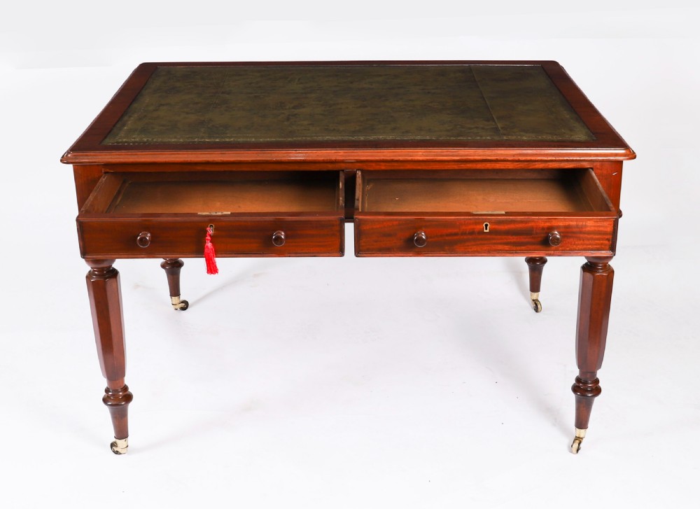 A nineteenth-century Victorian mahogany partners writing desk featuring a green leather inset top, frieze drawers with turned wood knob handles, and tapered legs on brass castors. View XI