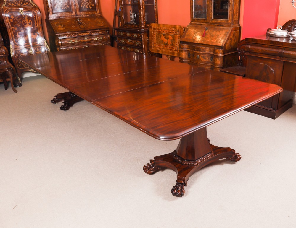 An extendable George IV Regency mahogany twin pedestal dining table with carved paw feet.