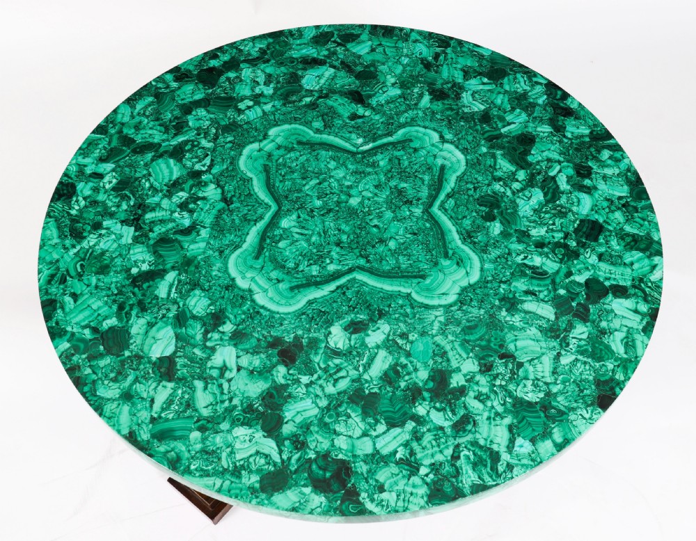 A round coffee table featuring a green malachite stone veneer top supported by three carved ebonised and giltwood winged sphinx legs on dark plinth bases. View VIII