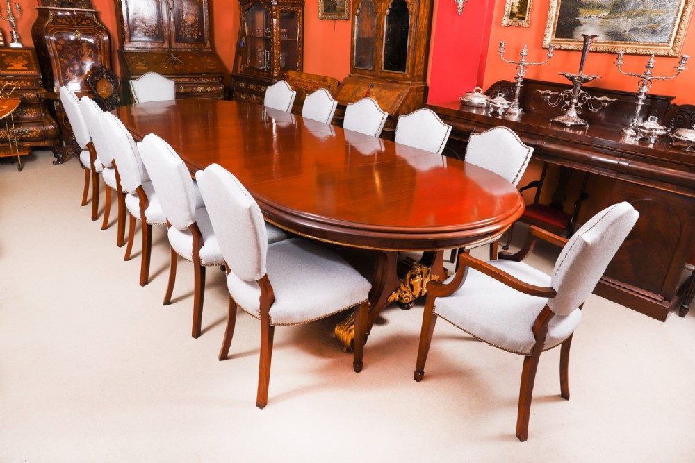 A large, polished mahogany extending dining table supported by two carved twin pedestals with parcel-gilt detailing. View II
