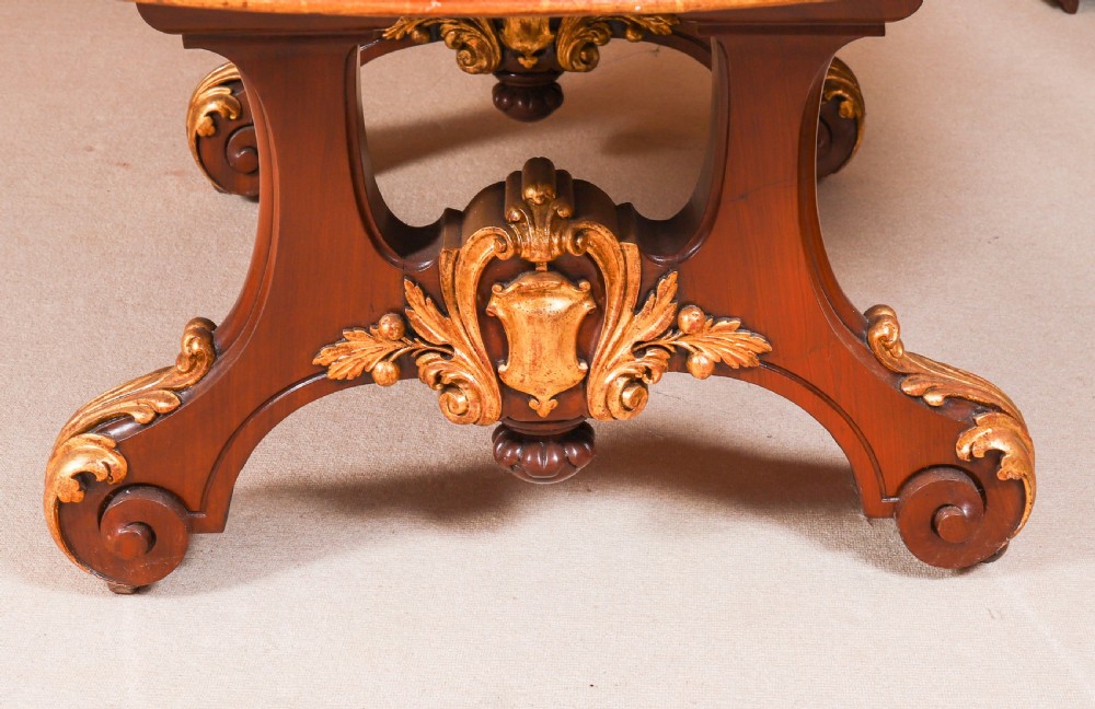 A large, polished mahogany extending dining table supported by two carved twin pedestals with parcel-gilt detailing. View XVII