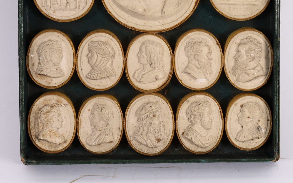An 18th-century boxed set of cream plaster Grand Tour intaglios showing classical profile portraits and Roman architectural scenes alongside an Italian manuscript index. View VI