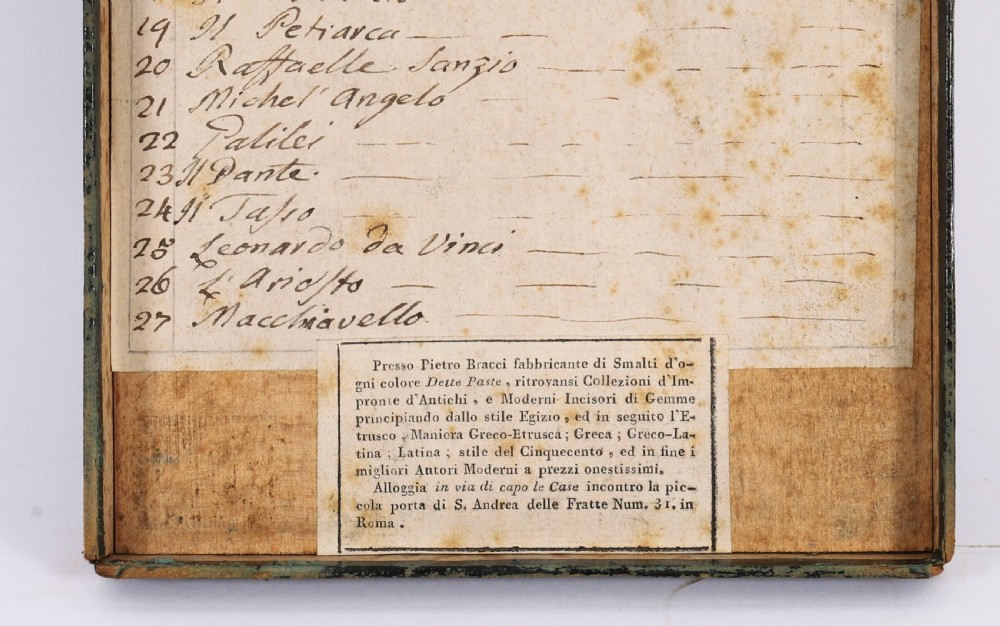 An 18th-century boxed set of cream plaster Grand Tour intaglios showing classical profile portraits and Roman architectural scenes alongside an Italian manuscript index. View VIII