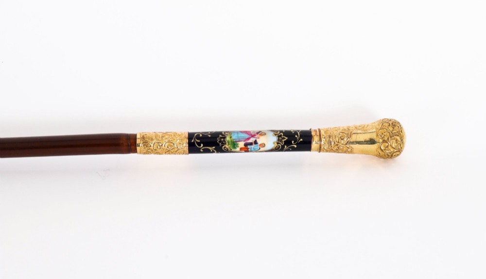 A 19th-century French sword stick featuring a chased gold-plated pommel and a hand-painted Sevres style cobalt blue porcelain collar above a wooden shaft with a partially drawn steel blade. View VIII