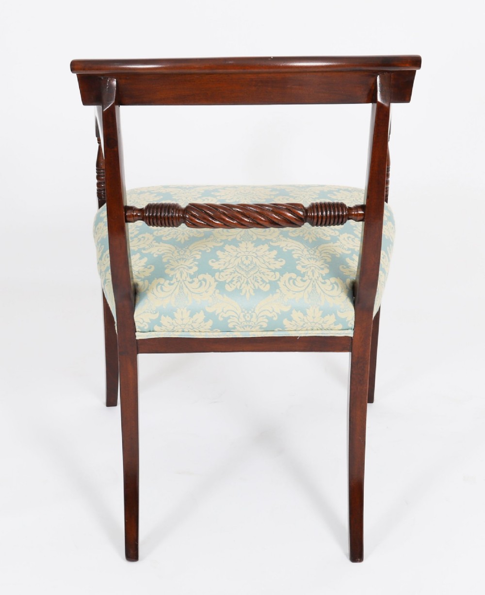 A set of eight Regency mahogany dining chairs, including two carvers, featuring curved top rails, rope-twist splats, and pale blue patterned upholstered seats. View X
