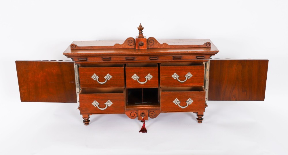 An antique Victorian walnut tabletop collectors cabinet featuring a front styled with vintage book spines, turned columns, turned feet, and a central finial top. View X