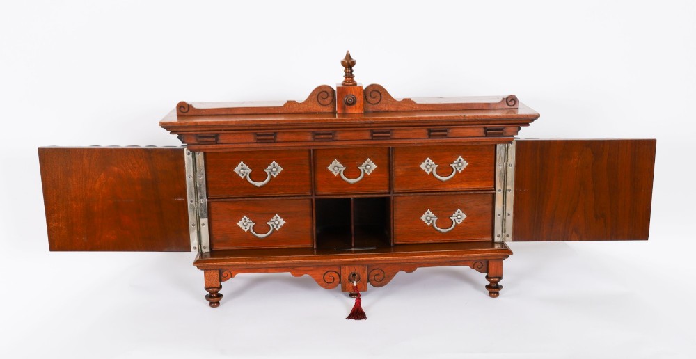 An antique Victorian walnut tabletop collectors cabinet featuring a front styled with vintage book spines, turned columns, turned feet, and a central finial top. View XI
