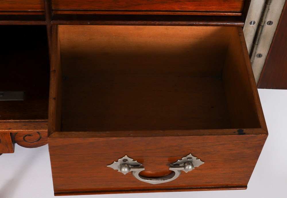 An antique Victorian walnut tabletop collectors cabinet featuring a front styled with vintage book spines, turned columns, turned feet, and a central finial top. View XII